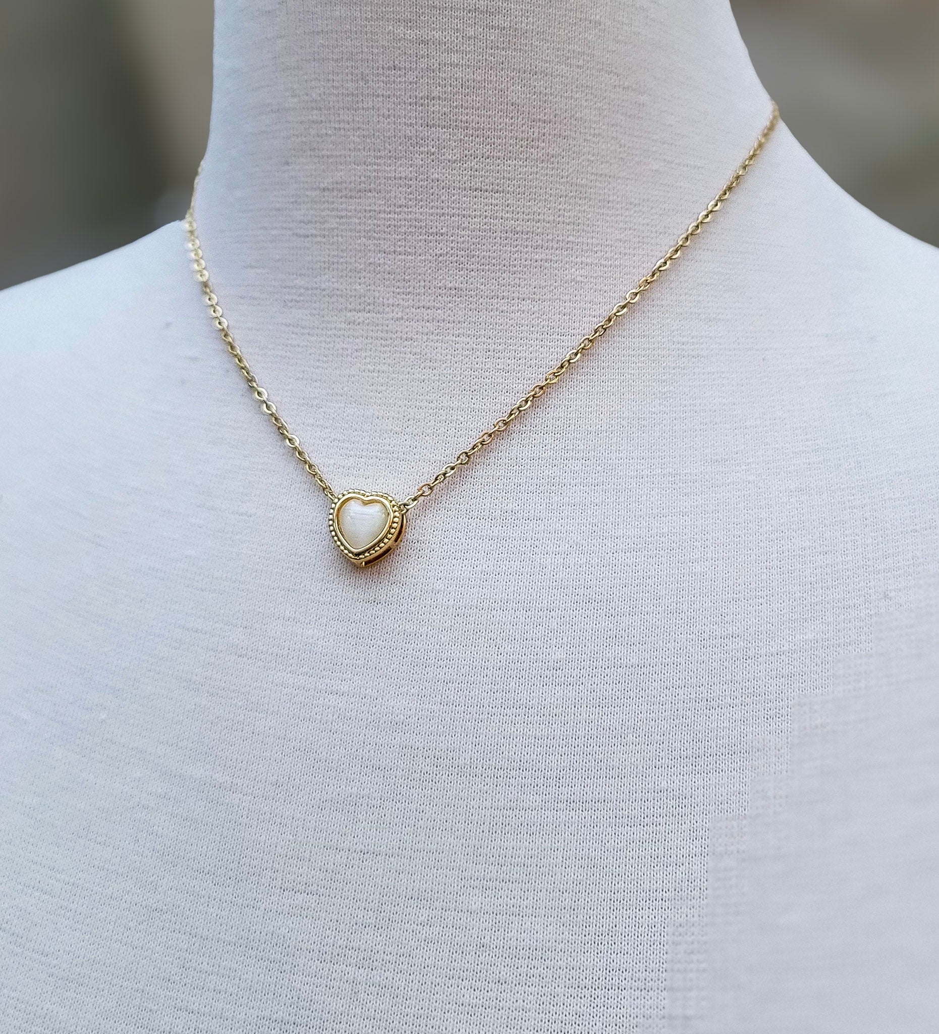 Detalle de collar con cadena dorada y corazón blanco – Trish T CoCo