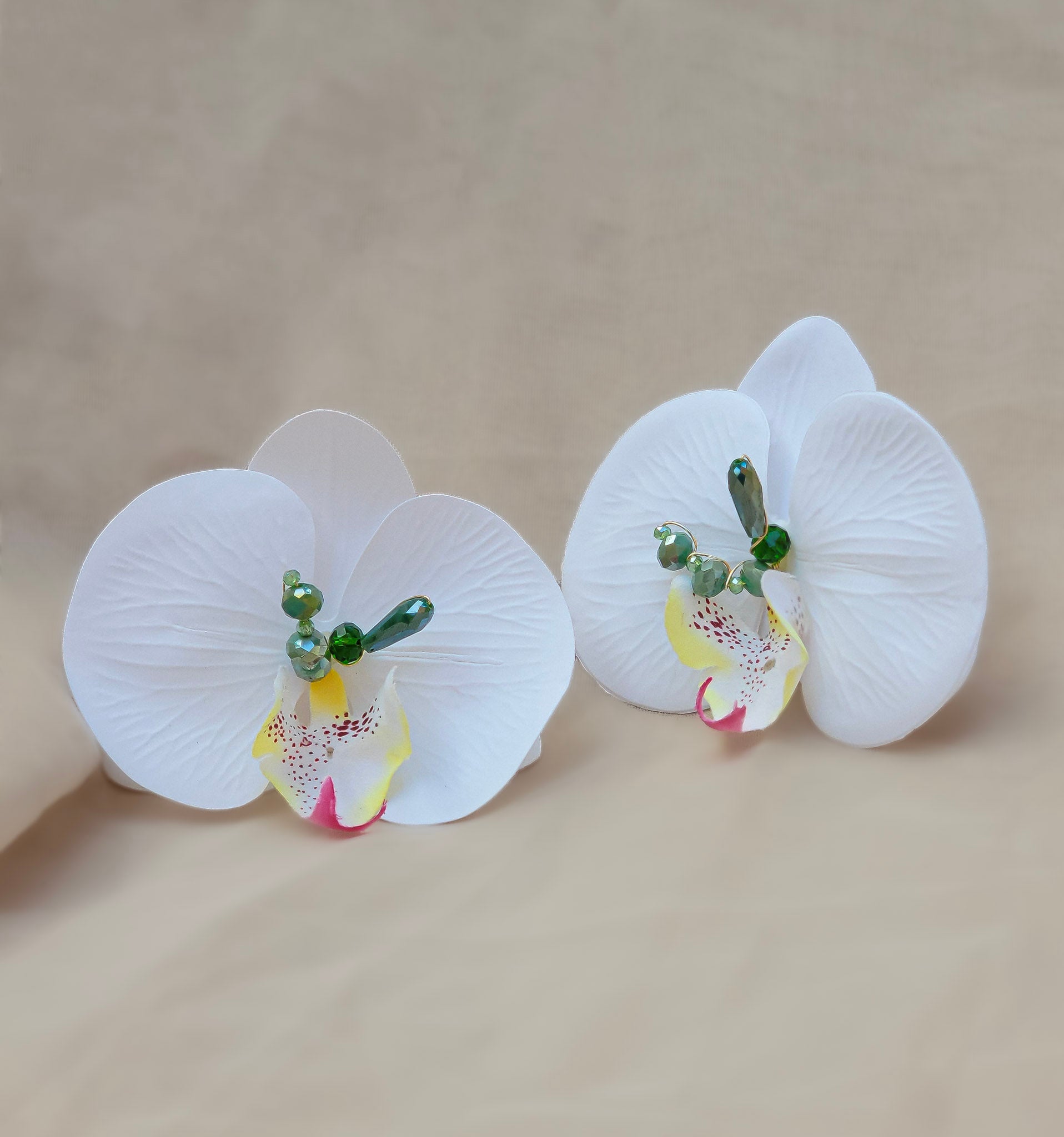 Pantallas orquídea blanca con cristales verdes sobre fondo beige – Trish T CoCo