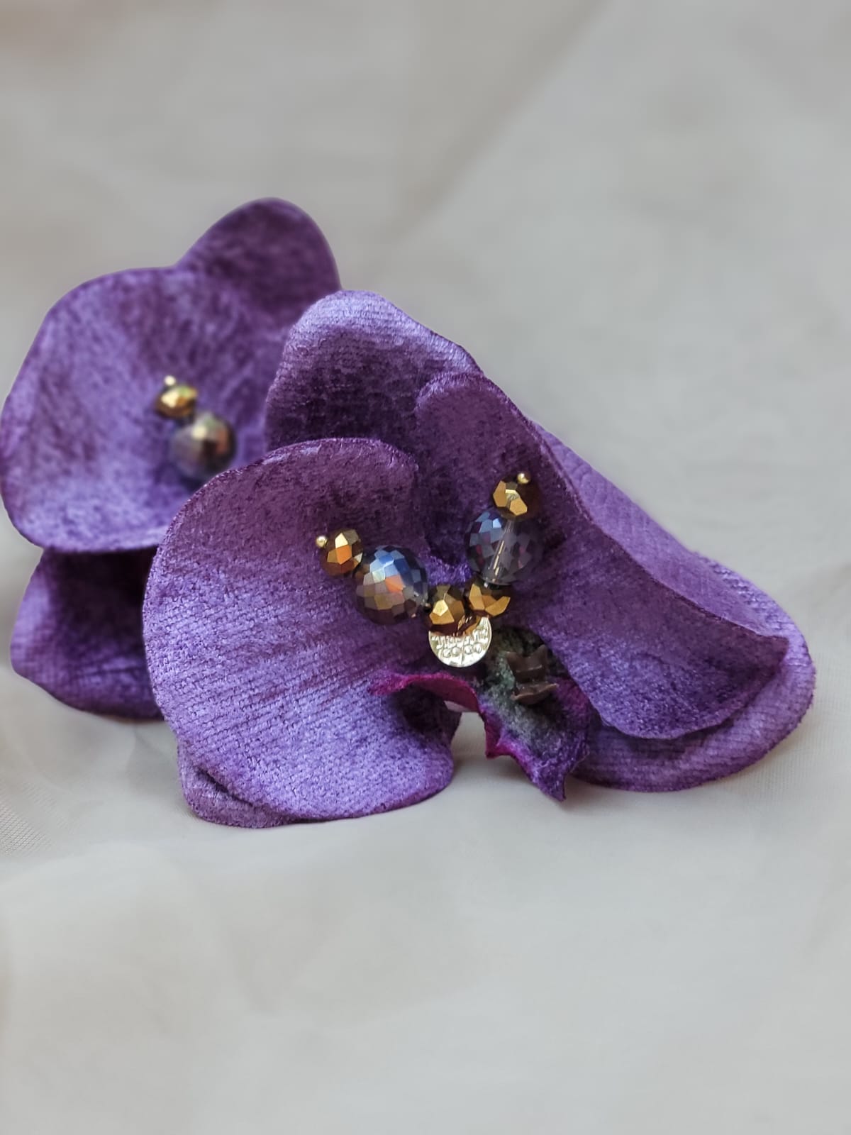 Descubre las Orquídea Nocturna de Trish T CoCo: pantallas florales hechas a mano con terciopelo violeta y cristales dorados. Inspiradas en el lujo tropical y el poder femenino.