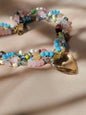 Collar multicolor con corazón transparente – vista frontal sobre tela dorada
